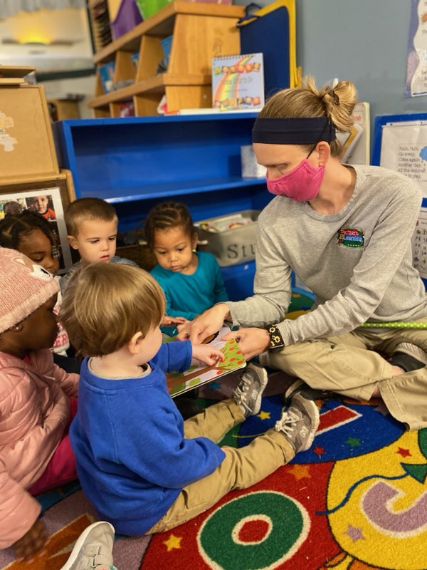 ECE teacher reading book to toddlers